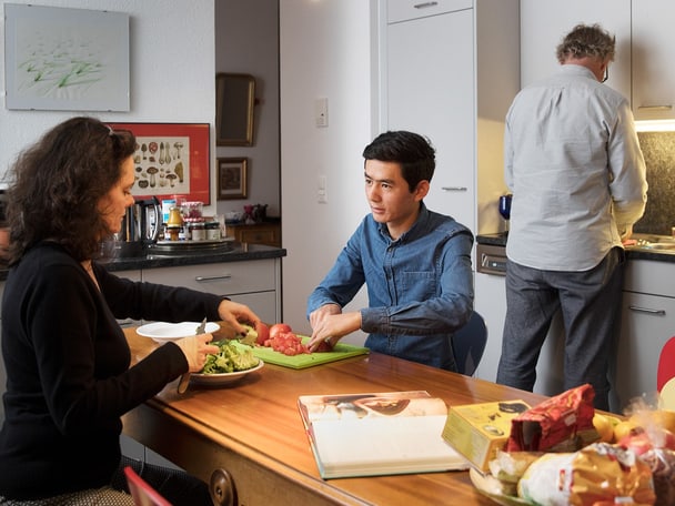 Geflüchtete Person bei Gastfamilie beim Kochen