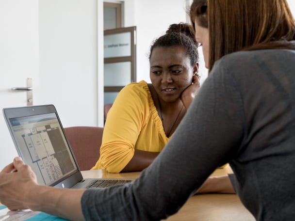 Beratungssituation mit zwei Frauen, die am Computer sitzen