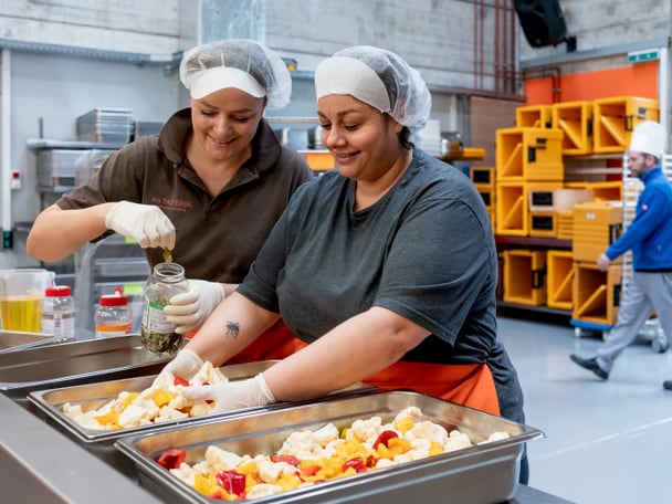 Zwei Menschen arbeiten in einer Küche.