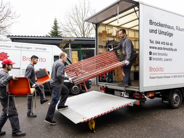 Mitarbeitende verladen Sofa in Transporter.