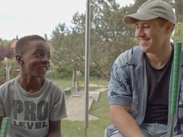 Mentor und Mentee sitzen nebeneinander und schauen sich an