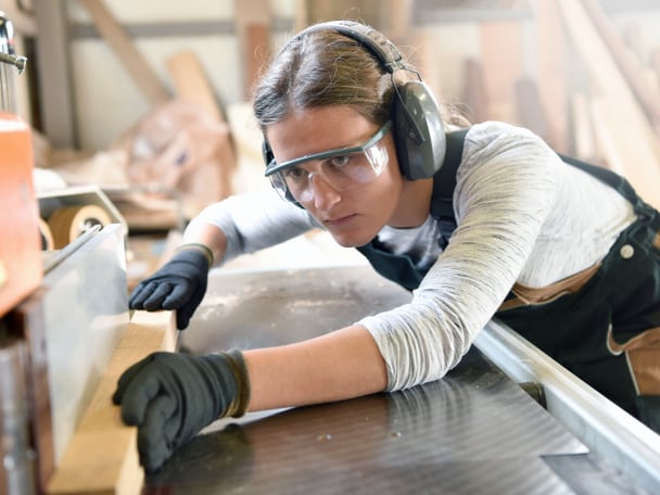 Junge Frau arbeitet in einer Werkstatt