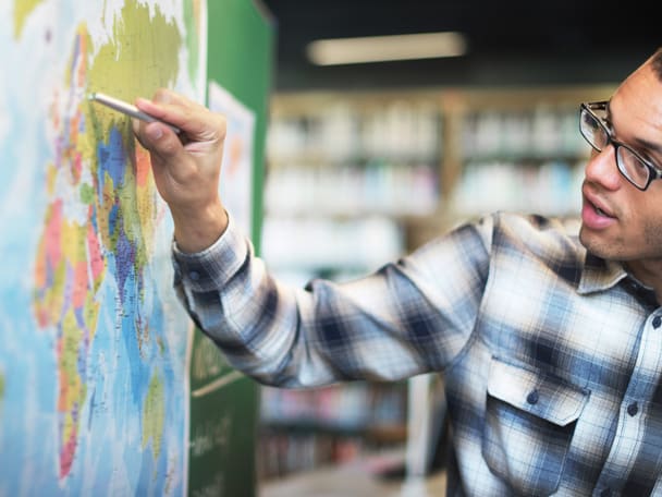 Lernender vor einer Weltkarte.