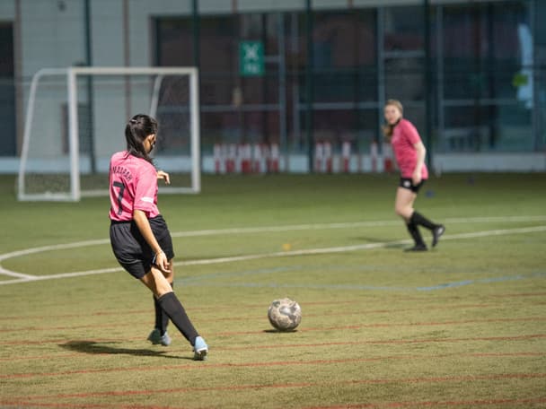 Zwei Menschen auf einem Fussballplatz.