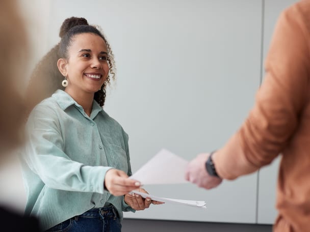 Eine Frau erhält von einer anderen Person ein Dokument