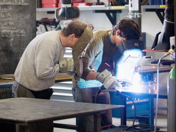 Zwei Mitarbeitende arbeiten in einer Schlosserei.