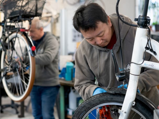 Mann repariert ein Velo.