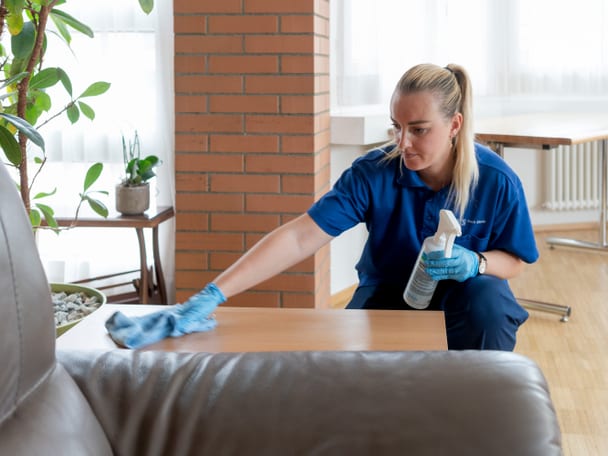 Eine Frau reinigt eine Oberfläche.