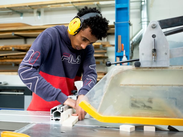 Mann arbeitet an einer Maschine. 