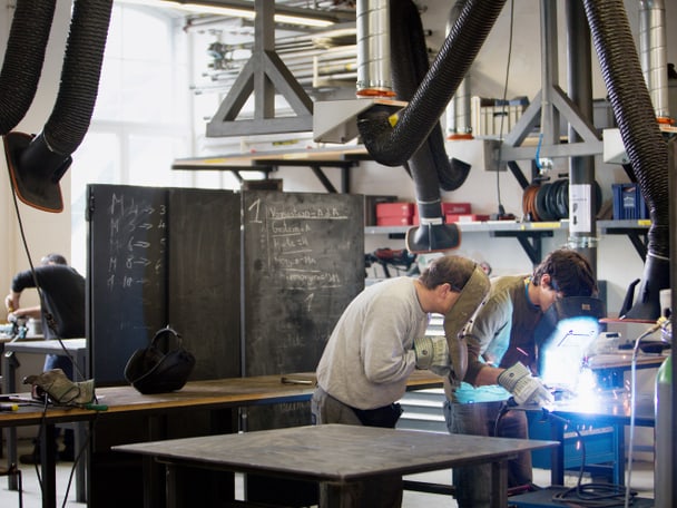 Zwei Mitarbeitende schweissen in einer Schlosserei.
