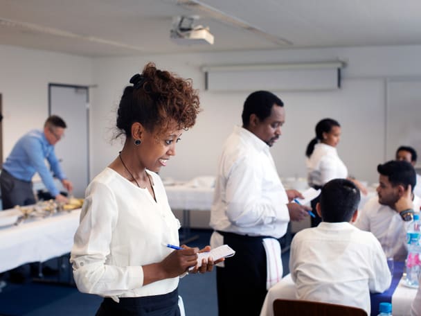 Eine Frau nimmt eine Essensbestellung entgegen.
