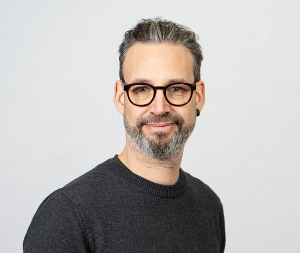 Porträtaufnahme Person vor grauem Hintergrund