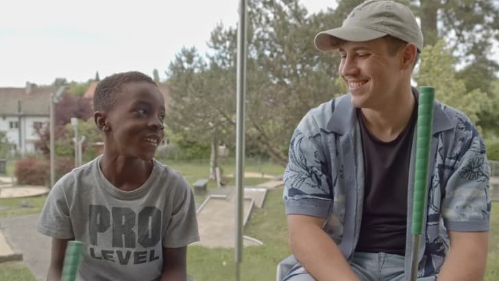 Mentor und Mentee sitzen nebeneinander und schauen sich an