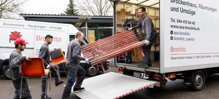 Mitarbeitende verladen Sofa in Transporter.