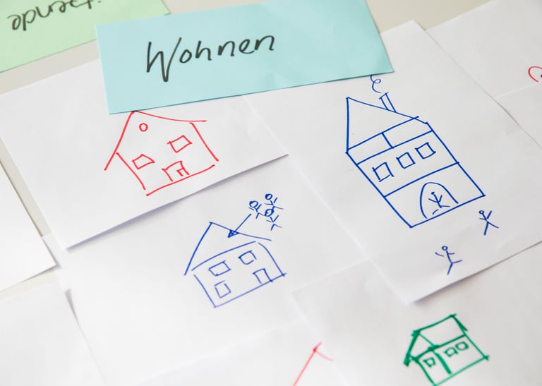 Post-its mit Zeichnungen von Häusern. 