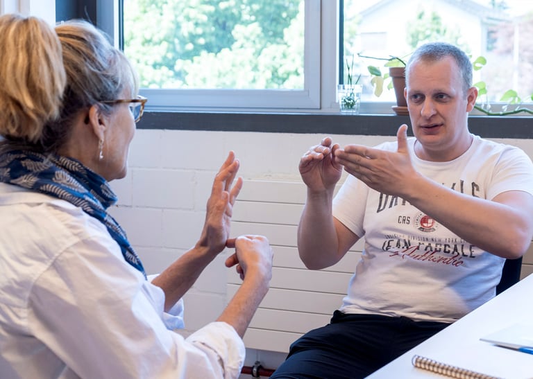 Zwei Menschen unterhalten sich in Gebärdensprache