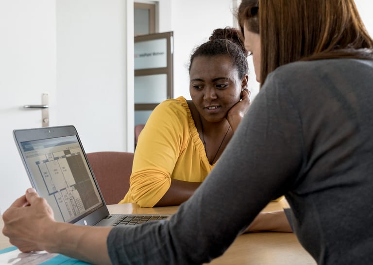 Beratungssituation mit zwei Frauen, die am Computer sitzen