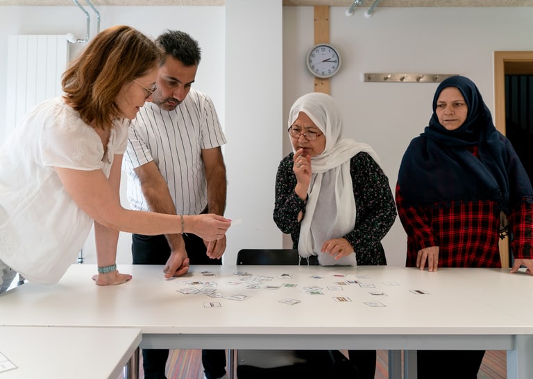 Menschen stehen am Tisch und lernen.