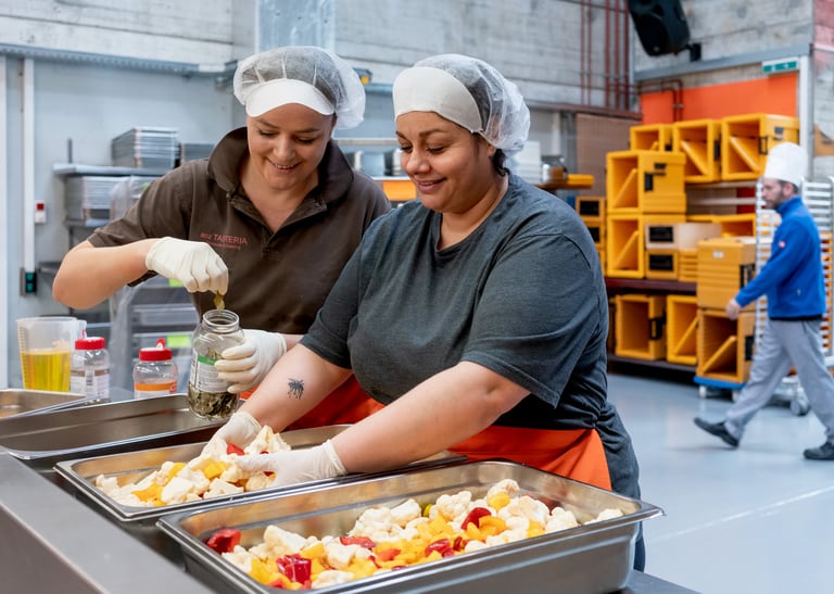 Zwei Menschen arbeiten in einer Küche.