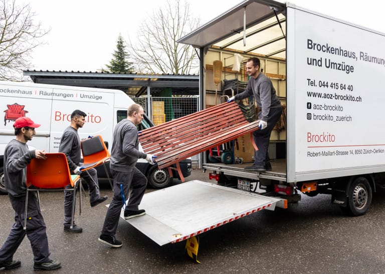 Mitarbeitende verladen Sofa in Transporter.