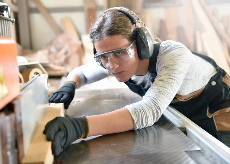 Junge Frau arbeitet in einer Werkstatt