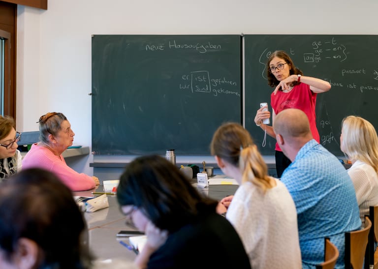 Eine Frau unterrichtet vor einer Klasse.
