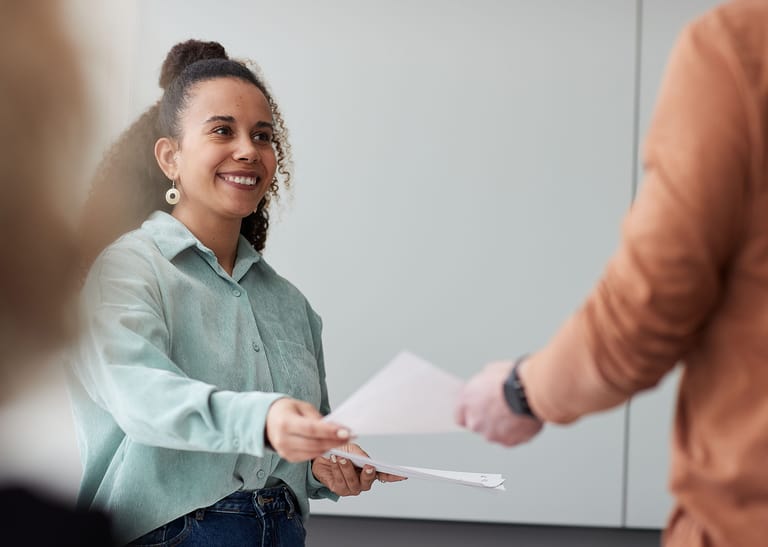 Eine Frau erhält von einer anderen Person ein Dokument