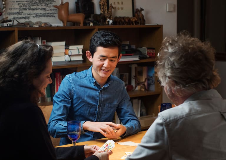 Junger Mann spricht mit Paar am Tisch