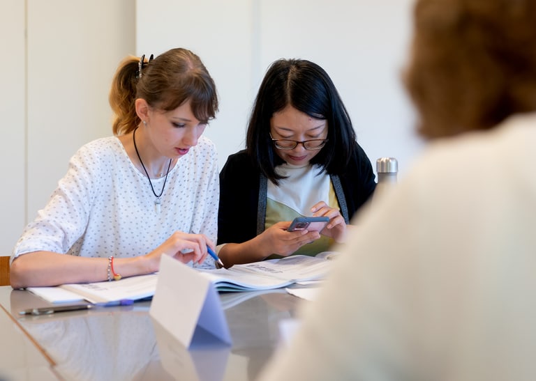 Zwei Kursteilnehmer am Aufgabe lösen