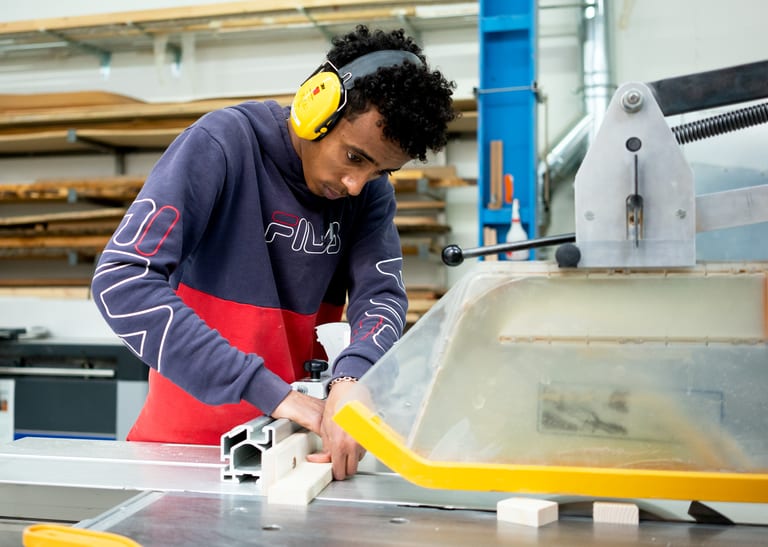 Mann arbeitet an einer Maschine.