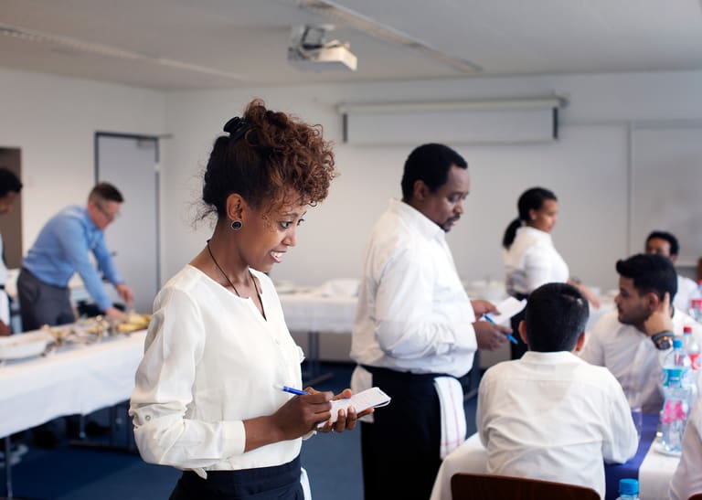 Eine Frau nimmt eine Essensbestellung entgegen.