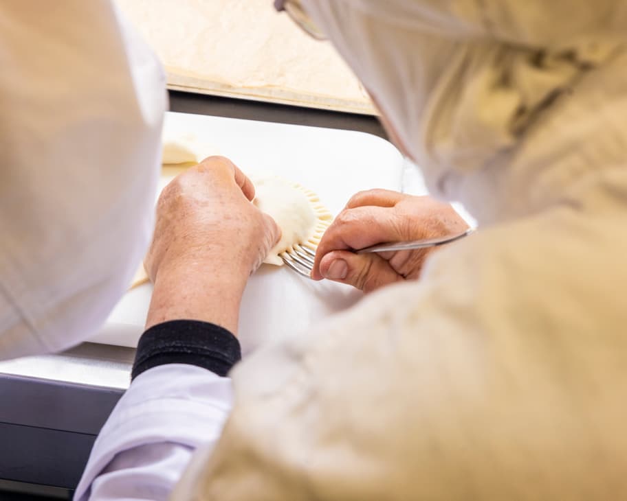 Eine Köchin verarbeitet Teigtaschen.