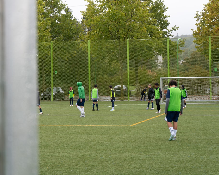 Kinder spielen auf dem Fussballfeld. 