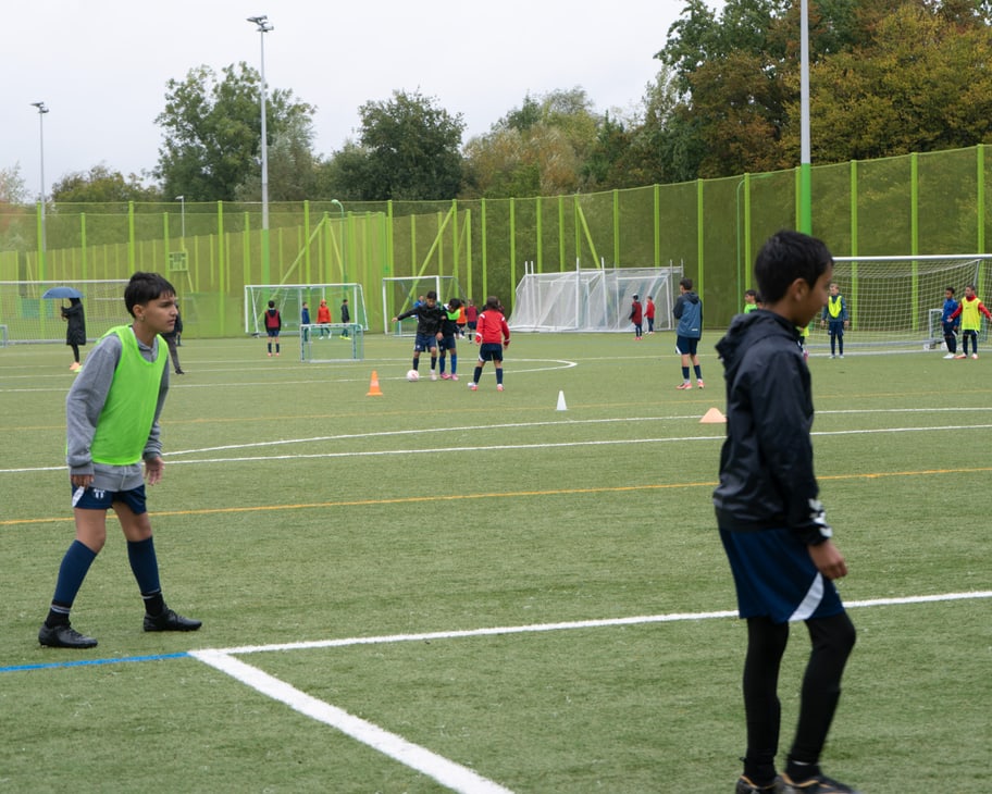 Die Kinder spielen auf dem Feld Fussball.