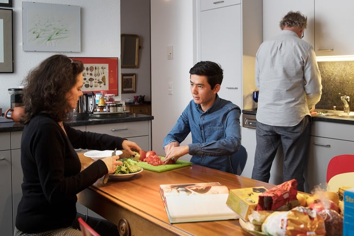 Geflüchtete Person bei Gastfamilie beim Kochen